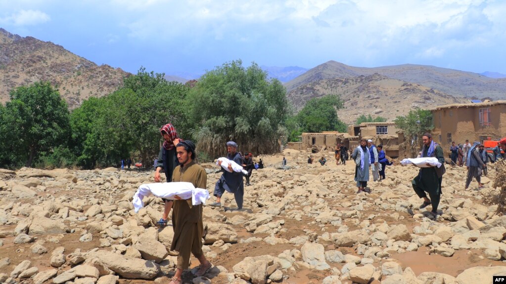 Le persone trasportano i corpi dei bambini morti a causa di inondazioni improvvise nella provincia centrale di Maidan Wardak in Afghanistan il 23 luglio. Negli ultimi tre giorni, le piogge stagionali hanno causato inondazioni che hanno ucciso almeno 31 persone e lasciato decine di dispersi.