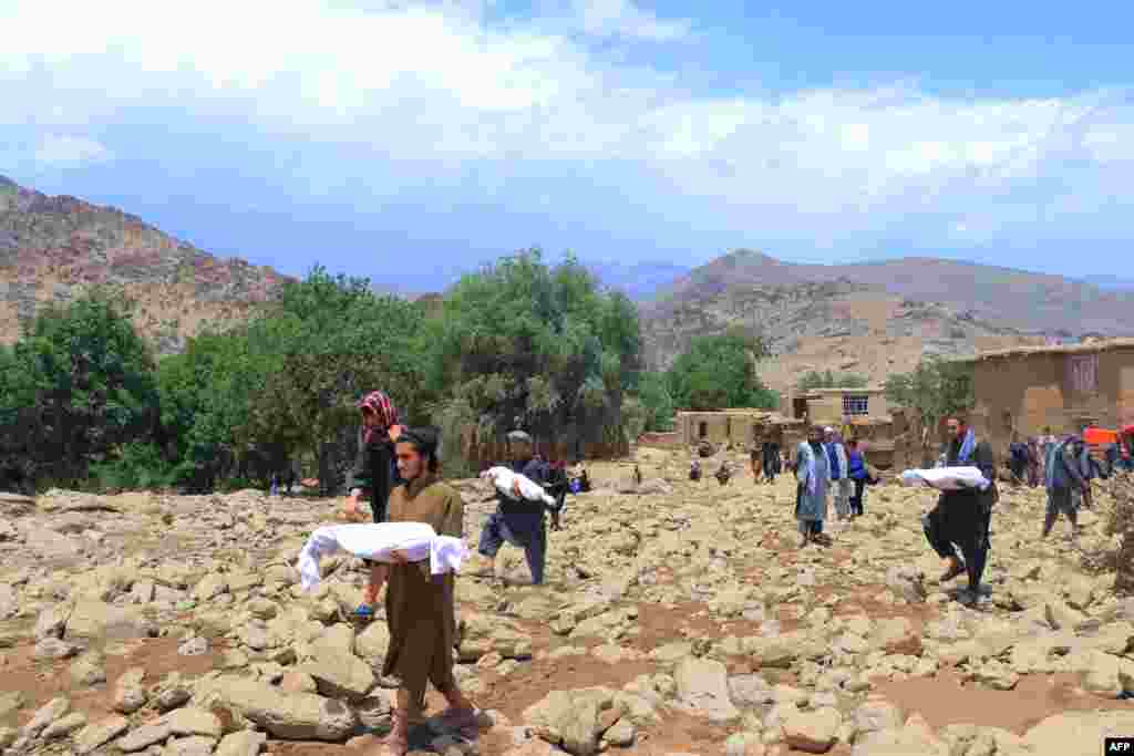 Njerëzit duke bartur trupat e fëmijëve që vdiqën nga përmbytjet e shpejta në distriktin Jalrez të provincës Maidan Wardak të Afganistanit.