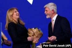 Petr Pavel megválasztott cseh köztársasági elnököt Zuzana Caputova szlovák elnök köszönti a színpadon a januári prágai választási estén.