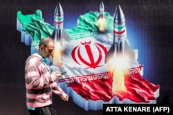 Un bărbat trece pe lângă un banner cu rachete lansate de pe o hartă a Iranului, la Teheran, la câteva ore după primul atac direct iranian asupra Israelului, în aprilie 2024.