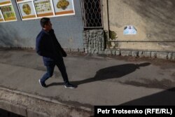 Мужчина проходит мимо агитационной листовки кандидата в депутаты. Алматы, 10 марта 2023 года