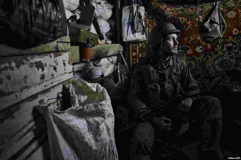 A Ukrainian soldier looks out from a dugout on the front line in the village of New York, Donetsk region, Ukraine.