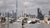 Një burrë duke ecur drejt makinave të bllokuara në ujërat e përmbytjeve të shkaktuara nga shiu i dendur në Dubai, Emiratet e Bashkuara Arabe, 17 prill 2024.<br />
<br />
Punonjësit e ekipeve emergjente filluan të pastronin rrugët pasi një stuhi e rrallë shkaktoi përmbytje në Emiratet e Bashkuara Arabe.<br />
&nbsp;