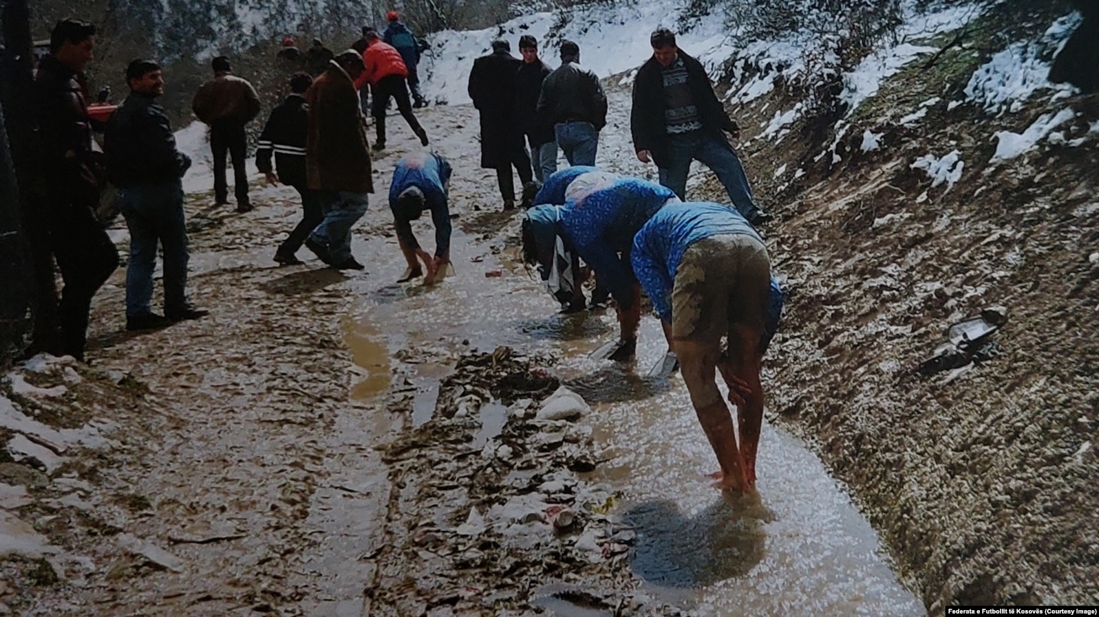 Futbollistë në vitet ‘90 duke u pastruar në një përroskë pas lojës në arë (Foto: Federata e Futbollit e Kosovës).