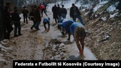 Futbollistë në vitet ‘90 duke u pastruar në një përroskë pas lojës në arë (Foto: Federata e Futbollit e Kosovës).