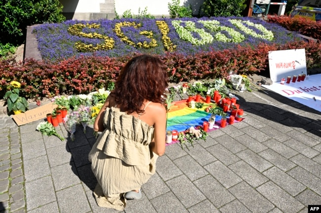 Женщина возлагает цветы к импровизированному мемориалу на месте теракта в Золингене. 24 августа 2024 года.