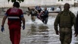 UKRAINE -- Emergency teams help rush to safety injured civilian evacuees who had came under fire from Russian forces while trying to flee by boat 