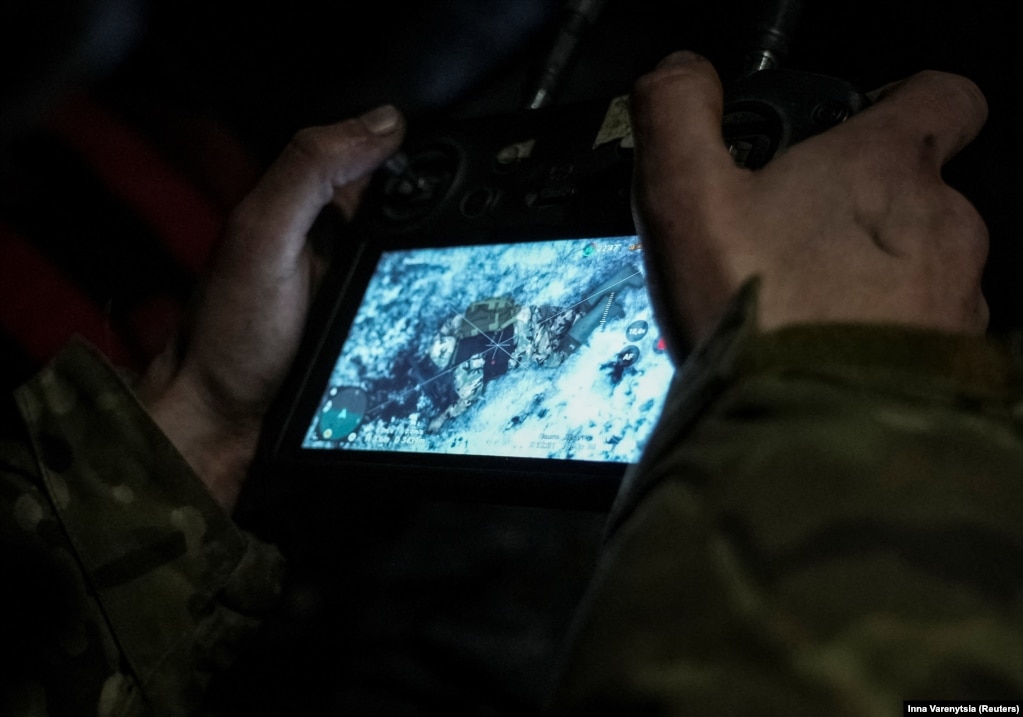 Një ushtar ukrainas shikon një monitor me pamjet nga droni që tregon trupin e një ushtari rus të vrarë nga një dron kamikaz FPV. Rusia dhe Ukraina po pozicionojnë mijëra dronë mbi fushën e betejës.
