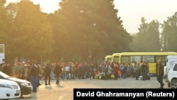 Residents gather next to buses in central Stepanakert before leaving Nagorno-Karabakh, September 25, 2023.