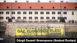 A Greenpeace-aktivisták molinója a Miniszterelnöki Kabinetirodának otthont adó Karmelita udvarnál az ukrajnai háború kezdetének évfordulóján