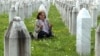 O femeie se roagă lângă pietrele funerare ale victimelor de la Srebenica, la cimitirul memorial din Potocari (Bosnia și Herțegovina). 