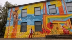 Alexandra Novak în fața unei clădiri proaspăt pictate. Imagine din arhiva personală