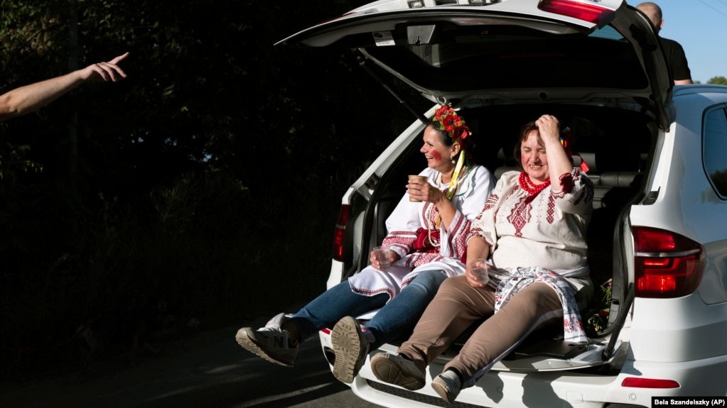 Nënat e çiftit të sapomartuar udhëtojnë në bagazhin e një veture gjatë ditës së dytë të festës së dasmës së tyre në periferi të Kievit. Në përputhje me traditën, pasi të dy familjeve po ua merrte fëmijët martesa, &nbsp;të dy nënat veshën rroba tradicionale ukrainase.