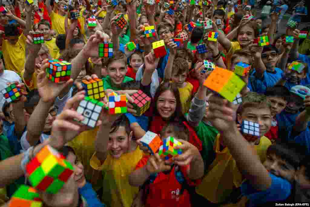 Students take part in a flash mob organized by the National Innovation Agency held on the occasion of the 50th anniversary of the invention of the Rubik&#39;s Cube on Szent Istvan Square in Budapest.