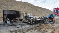A man walks past charred truck containers torched by the Baloch Liberation Army (BLA) in the central Bolan district in Balochistan Province on January 30.