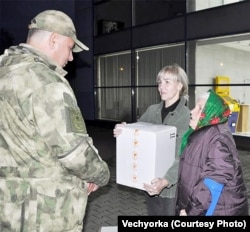 Një pensioniste ruse dhe vajza e saj duke i dhënë një kuti me çorape për ushtarët e njësisë "Gladiatori".