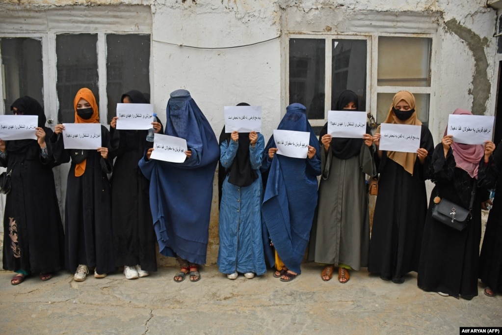 Donne afghane reggono cartelli che chiedono il loro diritto all'istruzione nella città settentrionale di Mazar-e Sharif a giugno.