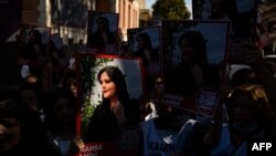 Demonstranti drže transparente sa portretom Mahse Aminija na skupu ispred iranskog konzulata u Istanbulu 29. septembra 2022.