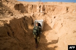 Fotografia din 2018 arată un ofițer israelian mergând spre intrarea unui tunel de pe partea israeliană a graniței cu Fâșia Gaza. Potrivit Israelului, a fost săpat de gruparea Jihadului Islamic și duce la Kibbutz-ul Kisufim din sudul Israelului.