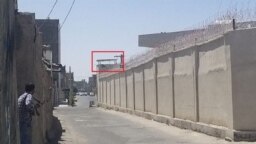 در عکس تسنیم، برجک کلانتری مشخص شده و یک نیروی لباس‌شخصی (چپ) اسلحه‌اش را به آن سمت نشانه رفته است