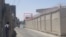 در عکس تسنیم، برجک کلانتری مشخص شده و یک نیروی لباس‌شخصی (چپ) اسلحه‌اش را به آن سمت نشانه رفته است