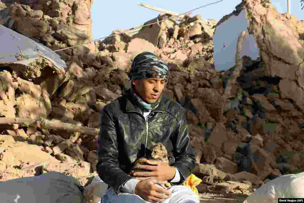 &nbsp;An Afghan youth holds his cat as he sits in a courtyard of his destroyed home. Mullah Janan Sayeeq, a spokesman for the Taliban&#39;s Ministry of Disasters, told a news conference that 2,440 people were dead, about 10,000 were injured, and that more than 2,000 houses had been damaged or destroyed.&nbsp;Afghanistan&#39;s disaster agency said on October 8 that 2,053 people had been killed. Neither estimate could be independently confirmed.