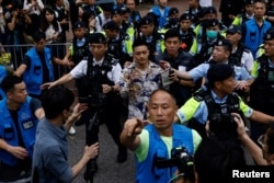 Lee Yue-shun, osuđeni aktivista kojeg sprovodi policija ispred suda nakon izricanja presude u Hong Kongu, 30. maj 2024.