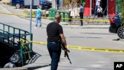 A Bosnian policeman attends a crime scene following a brutal triple homicide that was live streamed on social media on August 11. 