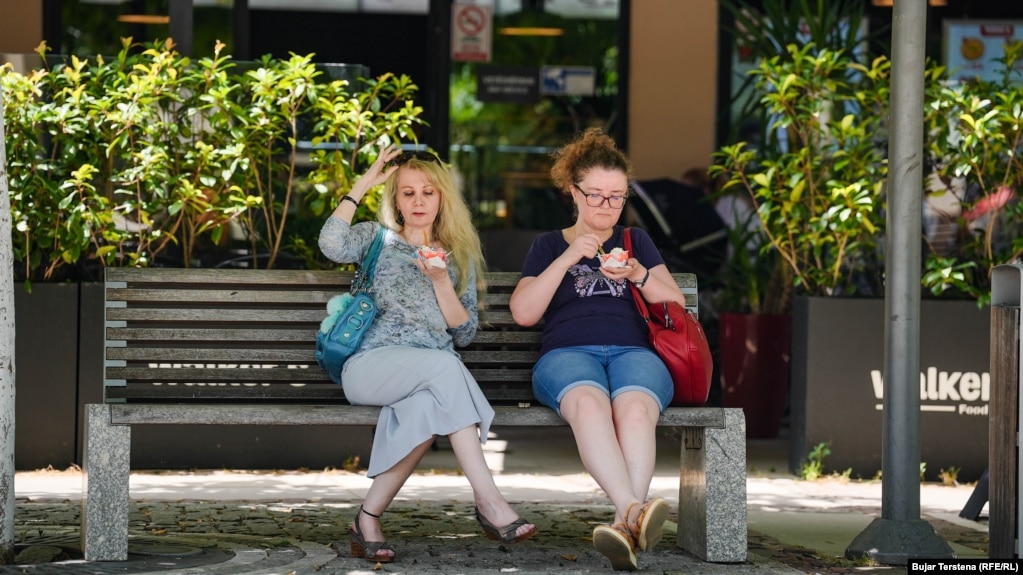 Dy qytetare në Prishtinë shijojnë akullore të ulura nën një hije, ndërsa temperaturat u ngritën në 34 gradë celsius më 21 qershor. &nbsp;