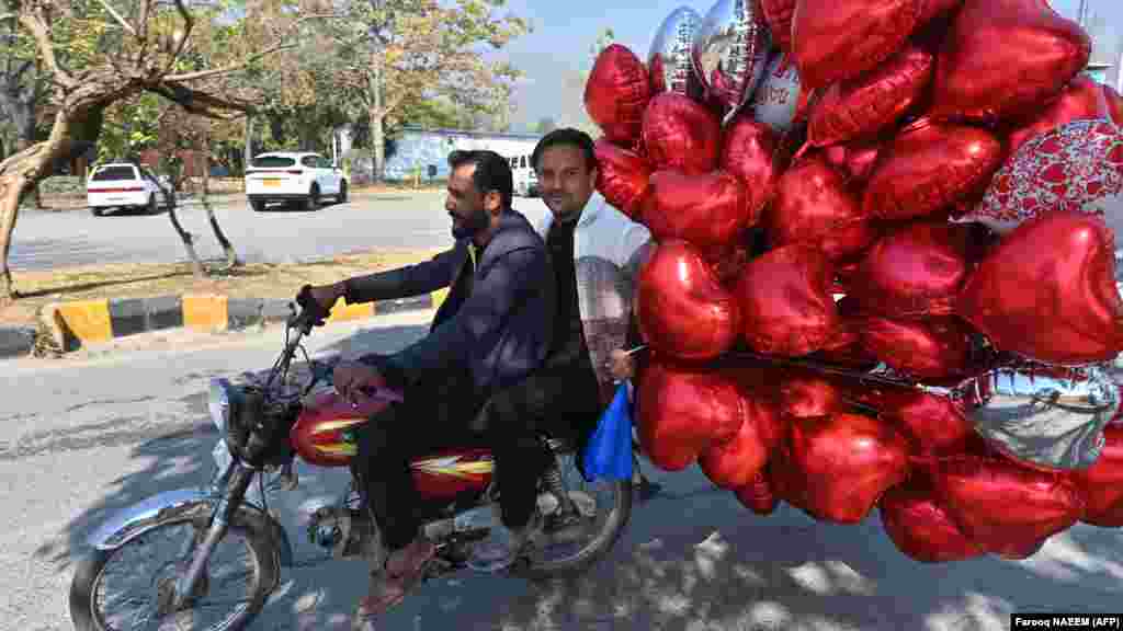 Muškarci voze motor nakon što su kupili balone u obliku srca na pijaci cvijeća na Dan zaljubljenih u Islamabadu 14. februara.