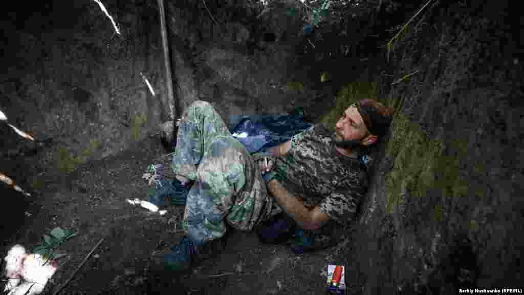 Denys, a Ukrainian soldier, takes a break during Russian shelling near Yakovlyvka in the Donetsk region on August 29, 2022. In peacetime, he worked as an archaeologist.