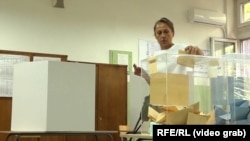 A woman casts her vote in repeat local elections in Belgrade on June 2