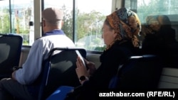 Türkmenistanda jemgyýetçilik awtobuslarynyň birinde mobil telefonuna seredip barýan zenan (Arhiwden alnan illýustrasiýa suraty)