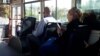 Пассажиры в автобусе с мобильными телефонами в руках. Ашхабад (Иллюстративное фото) 