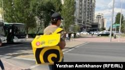 Yandex қызметімен тамақ тасып жүрген тұрғын. Көрнекі сурет.