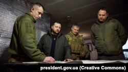 Ukrainian President Volodymyr Zelenskiy (second left) discusses the military situation with troops on a visit to Avdiyivka late last month.