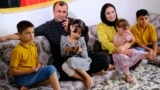 Afghan Seema Stanikzai sits with her husband, Jan Mohammad Habibi, and their four children in their new home in Nuremberg, Germany.