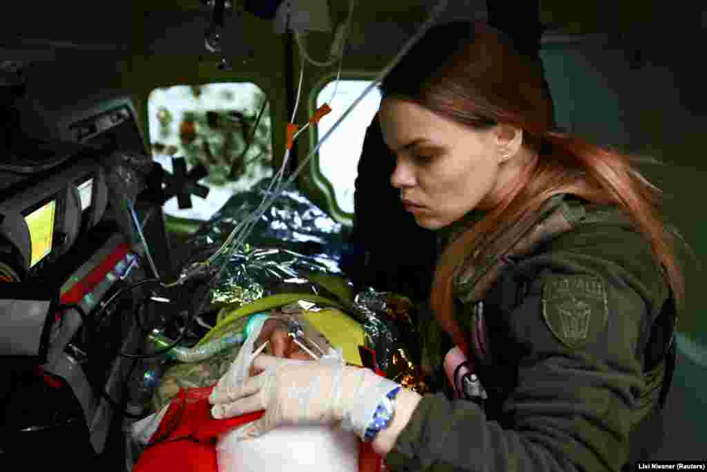 Marjana, an intensive care medic, tends to a wounded Ukrainian soldier in an ambulance as he is transported from a field hospital near the front line of Bakhmut to a specialist trauma hospital in the city of Kramatorsk.