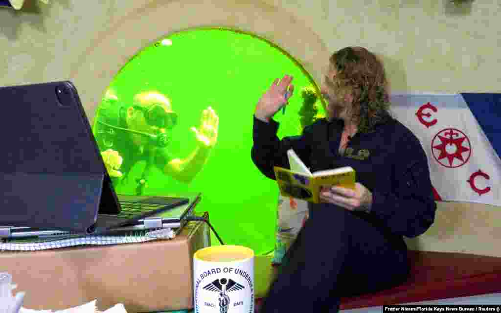 Američki istraživač Joseph Dituri (desno) maše roniocu, Florida, SAD, 13. maj. Dituri je oborio svjetski rekord u broju provedenih dana pod vodom, bez promjene pritiska. Proveo je više od 74 dana na dnu lagune duboke gotovo deset metara u Key Largu - i ne želi da se na tome zaustavi. Kako je izjavio, planira da na tom mjestu provede još 100 dana.