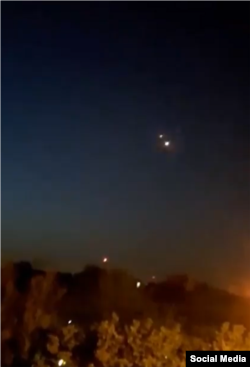 Captură video dintr-o postare de pe X (fosta Twitter), care ar fi surprins explozii aeriene în apropiere de o bază militară iraniană.