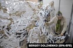 Російська пенсіонерка плете маскувальну сітку для фронту