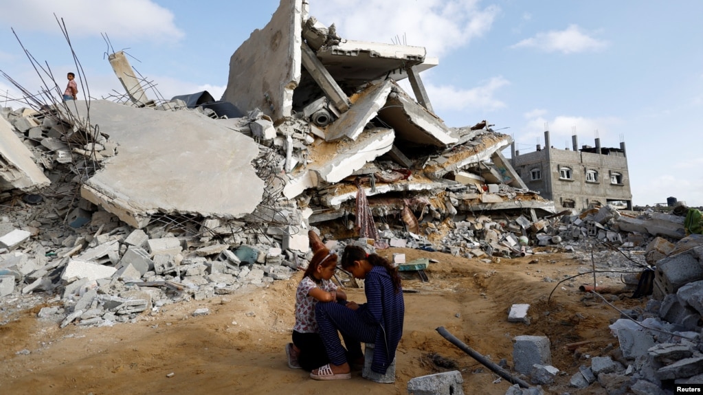 Деца в Газа на фона на срутена сграда в Рафах