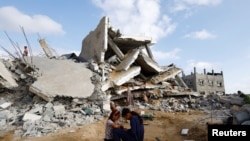 Palestinska djeca sjede među ruševinama u Rafahu, južno područje Pojasa Gaze, 21. april 2024.