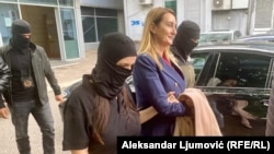 Jelena Perovic, the director of Montenegro's Anti-Corruption Agency, is escorted by investigators in Podgorica on April 17. 