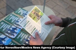 A man reads a leaflet promoting Russian mobilization.