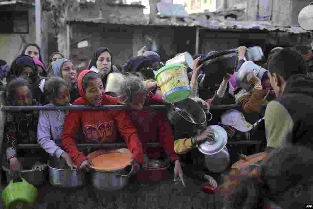 Raseljeni Palestinci čekaju na hranu koju je donirala dobrotvorna organizacija pred iftar, u Rafahu, na jugu Pojasa Gaze, 11. marta. UN i humanitarne grupe kažu da je za samo djelić zaliha potrebnih za 2,4 miliona stanovnika Gaze dozvoljen ulazak otkako ju je Izrael stavio pod skoro potpunu opsadu nakon napada 7. oktobra 2023..