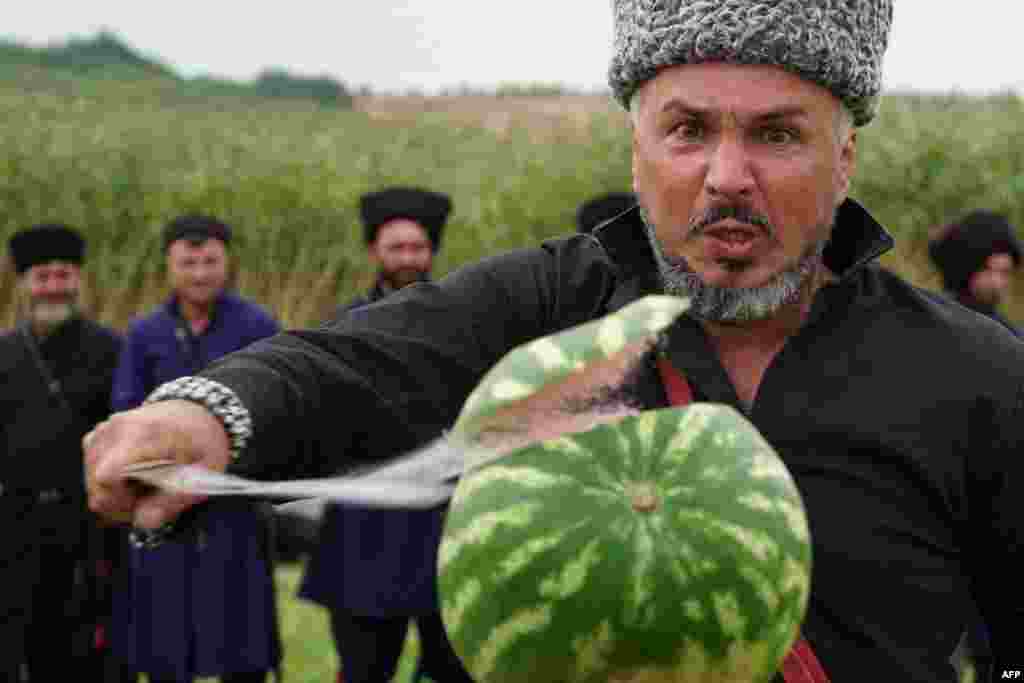 A Cossack slashes a watermelon with a saber during a saber-cutting competition in the village of Novosvetlovsky in Russia&#39;s western Rostov region.