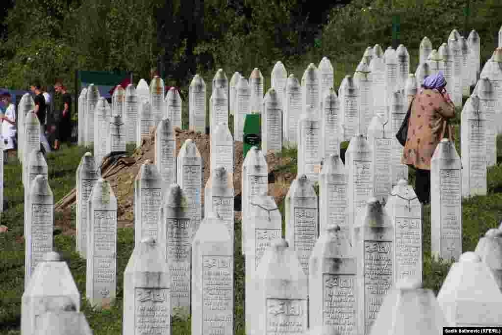 A woman walks among the graves in Potocari following the ceremony.