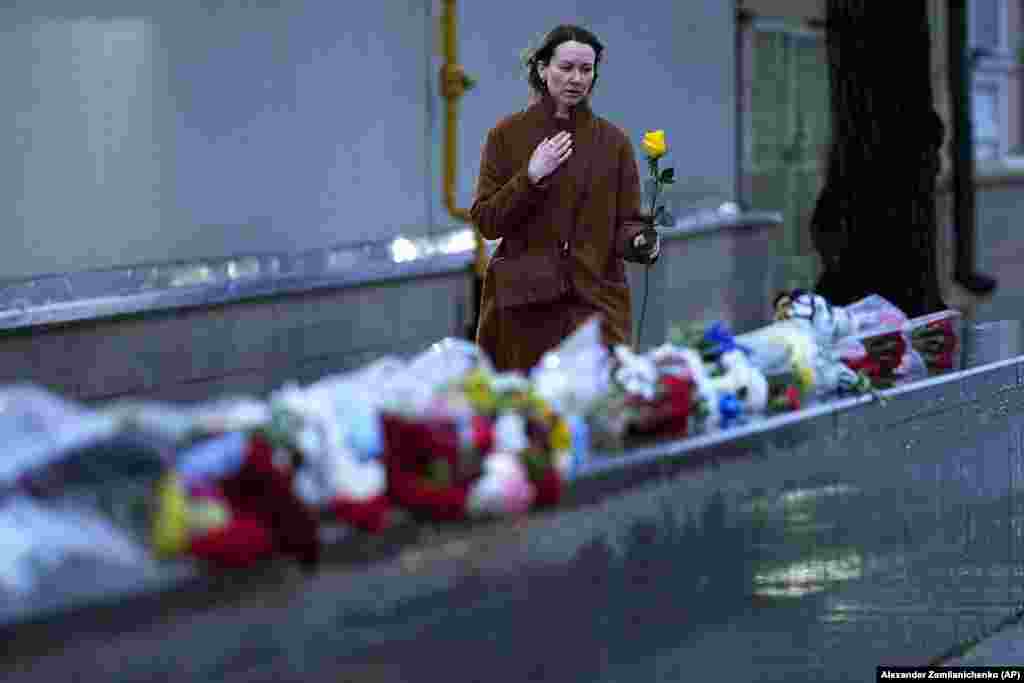 A woman lays flowers in memory of victims of the surprise attack from Gaza in front of the Israeli Embassy in Moscow.