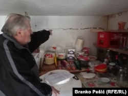 Vukasin Lazarevic shows the cracks in the wall in the pantry of his home, which he says is due to explosions from the nearby mine.
